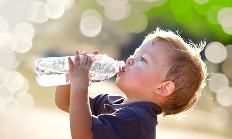 Little boy drinking water from a water bottle.
