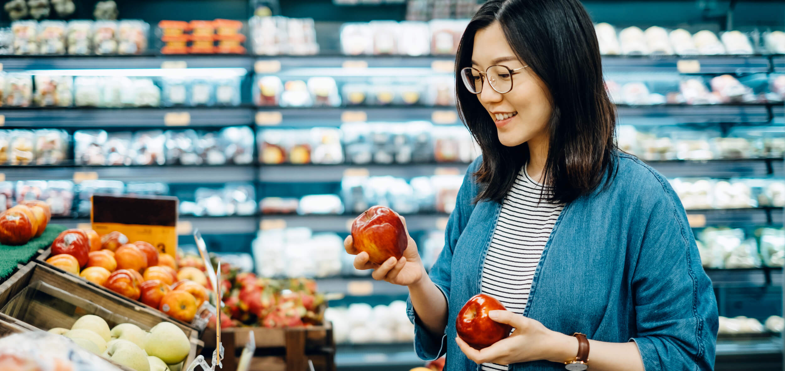 Woman shopping apples in grocery store
