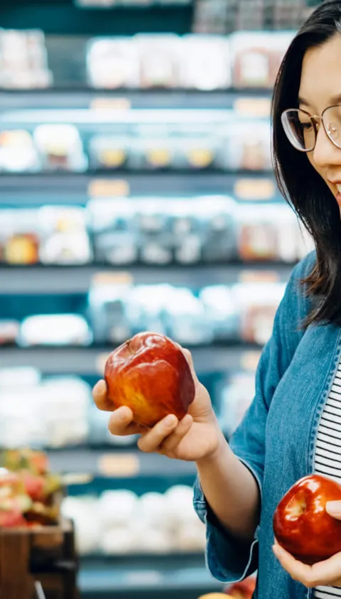 Woman shopping apples in grocery store
