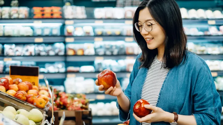 Woman shopping apples in grocery store